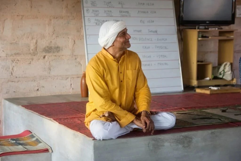Dr. Ashutosh seated cross-legged during a yoga teaching session.